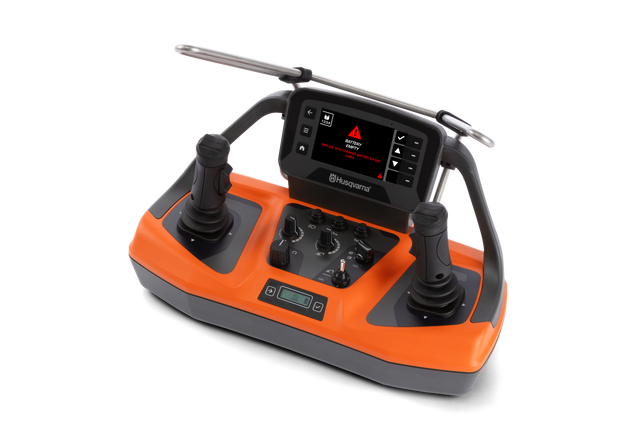 Front view of a Husqvarna control unit with dual joysticks, knobs, and a battery warning.