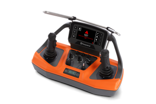 Front view of a Husqvarna control unit with dual joysticks, knobs, and a battery warning.