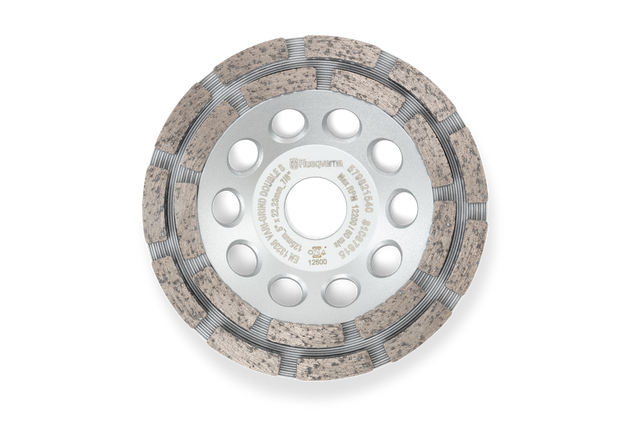 Top view of a Husqvarna construction grinding disc with multiple holes and textured surface.