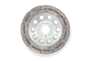 Top view of a Husqvarna construction grinding disc with multiple holes and textured surface.