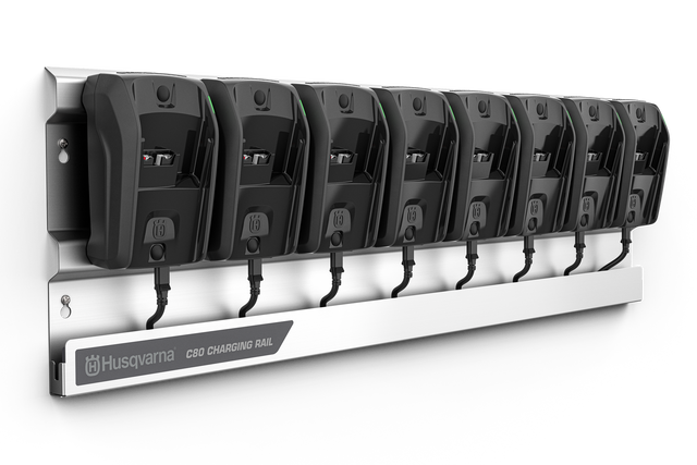 Un rail de charge Husqvarna sur lequel sont montés huit chargeurs de batterie.